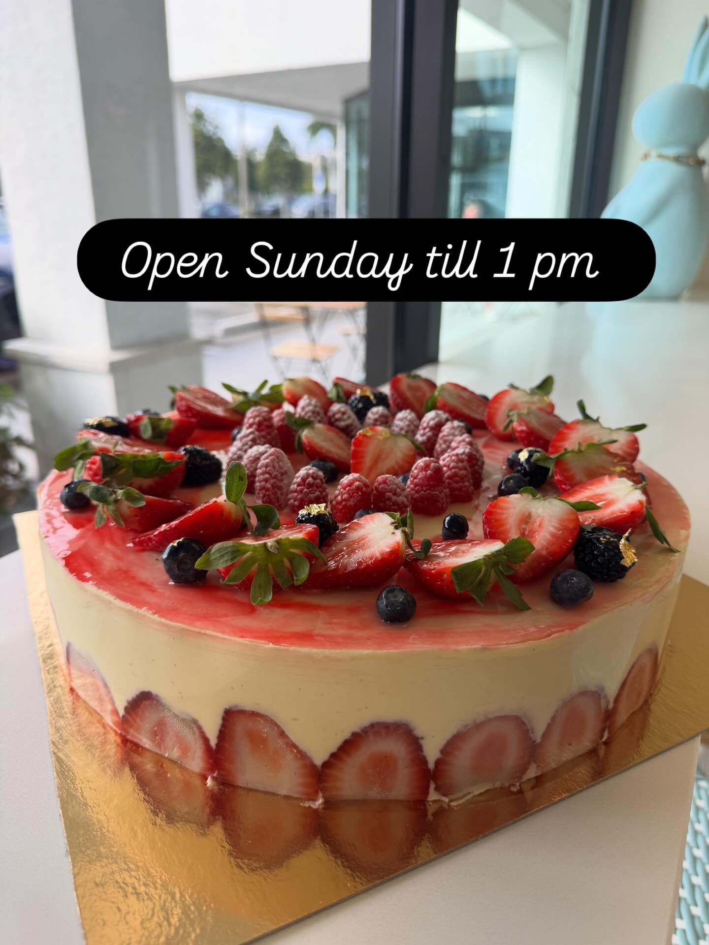 Mixed berry cream cake near the storefront window