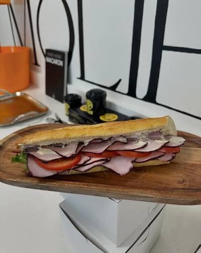 A ham and cheese baguette sandwich with lettuce and tomato