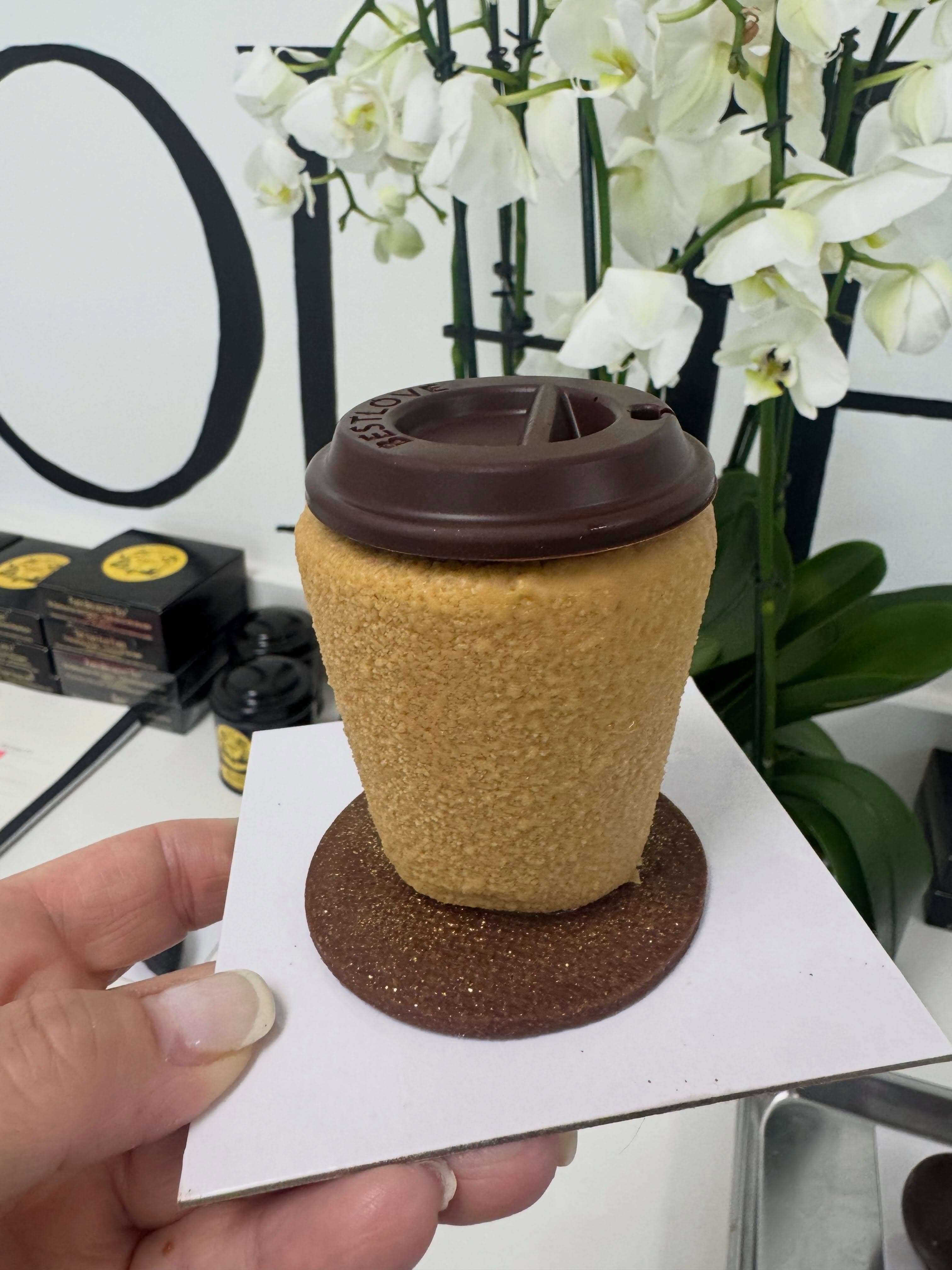 A trompe-l'œil pastry shaped like a to-go coffee cup