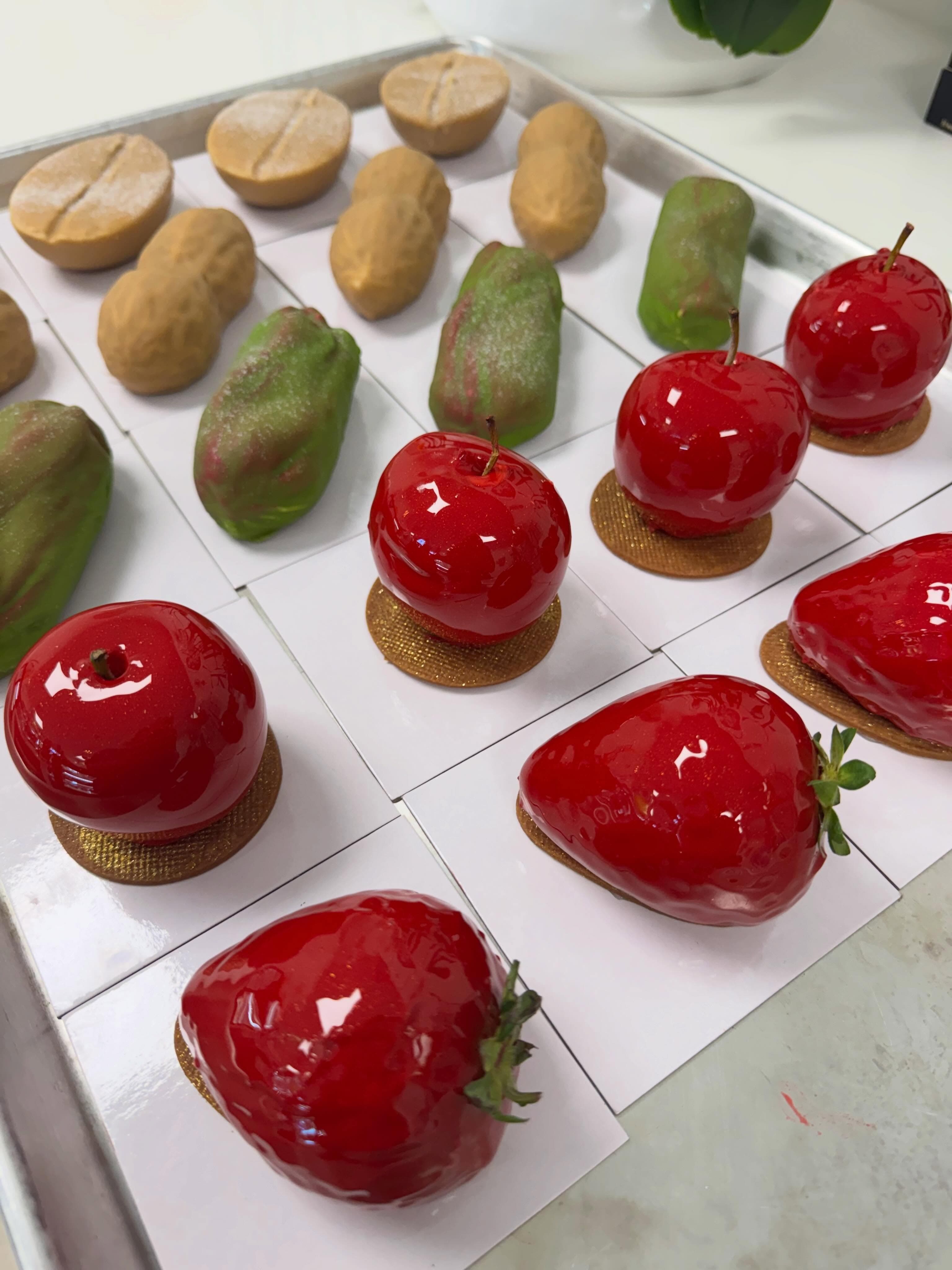 A tray of trompe-l'œil pastries shaped like apples, cherries, pears and walnuts