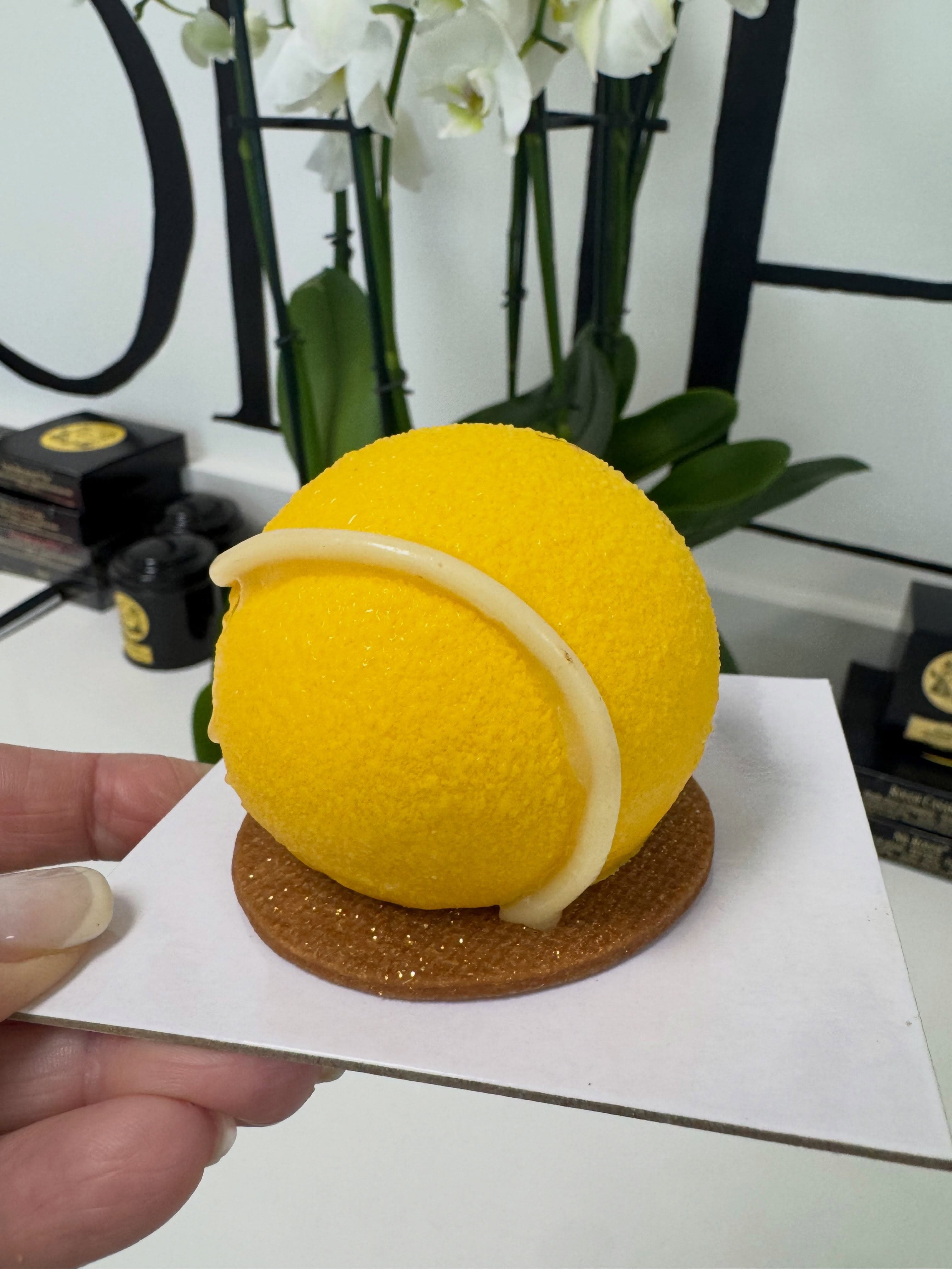 A trompe-l'œil pastry shaped exactly like a lemon